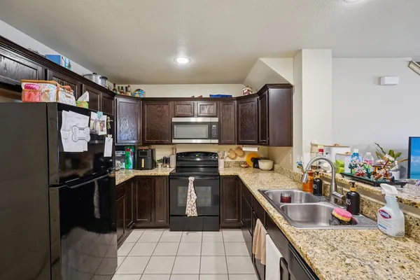 a kitchen with stainless steel appliances granite countertop a sink stove and refrigerator
