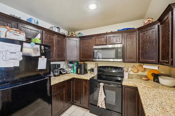 a kitchen with stainless steel appliances granite countertop a stove a sink and a microwave