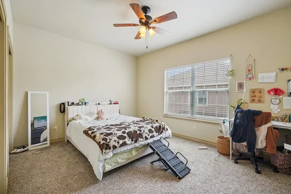 a bedroom with a bed a table and a chandelier