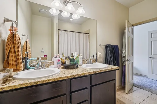 a bathroom with a granite countertop sink and a mirror