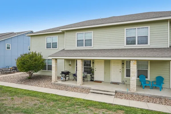 a view of a house with backyard and chairs
