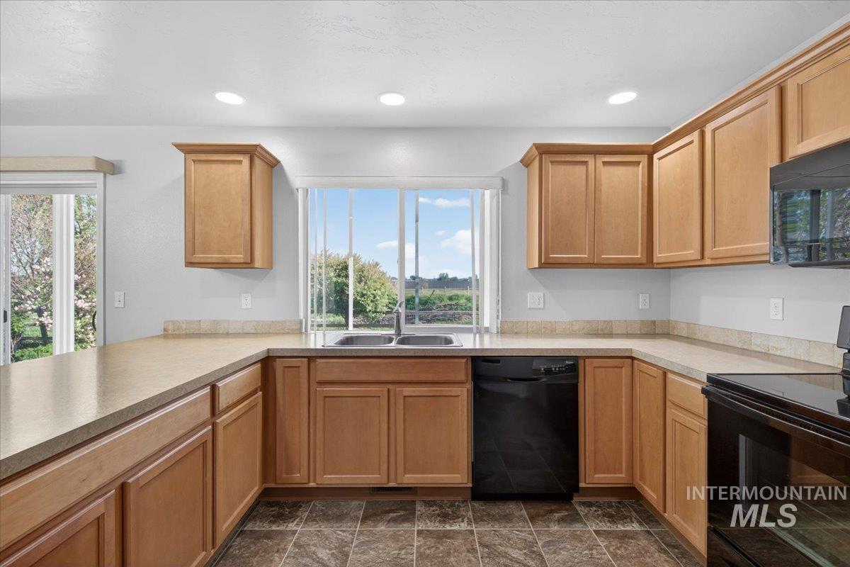 1555 Condor Drive Middleton, ID 83644 - Photo 7 of 50 Kitchen featuring light wood cabinetry, recessed lighting, double basin sink, black dishwasher, and black range