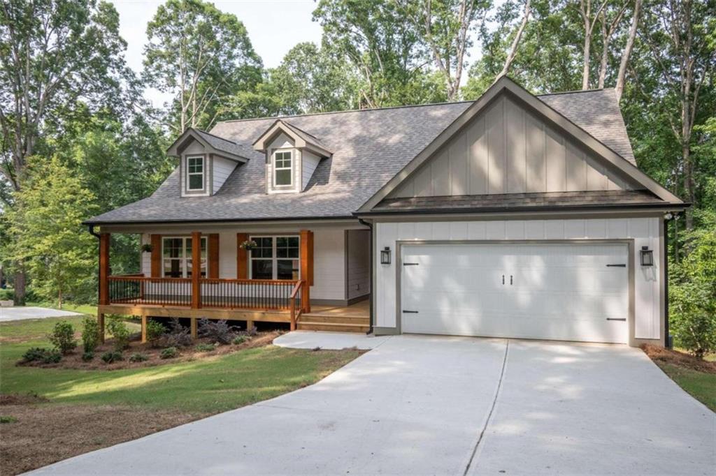 a front view of a house with a garden and trees