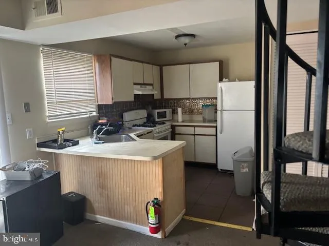 a kitchen with a refrigerator a stove a sink and a window