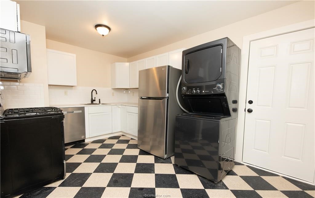 535 Husk Somerville, TX 77879 - Photo 5 of 9 a kitchen with a checkered floor and a black refrigerator
