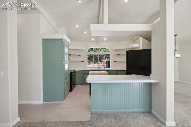 a large kitchen with stainless steel appliances a large counter top