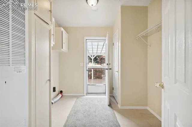 a view of a livingroom with kitchen space and windows