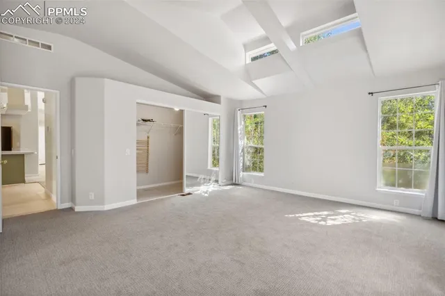 an empty room with windows and closet