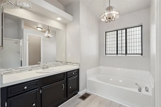 a spacious bathroom with a tub sink and mirror