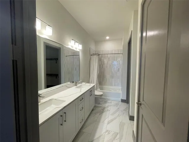 a bathroom with a double vanity sink and a mirror