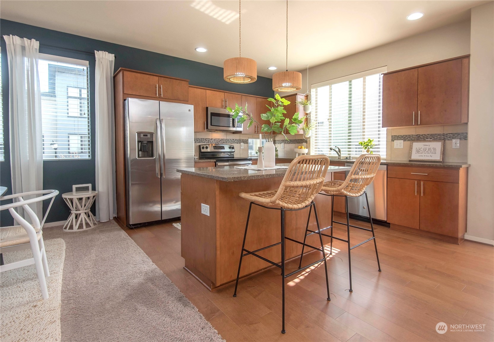 4525 Northeast 3rd Lane Renton, WA 98059 - Photo 10 of 26 a kitchen with stainless steel appliances granite countertop a stove a refrigerator a sink a dining table and chairs with wooden floor