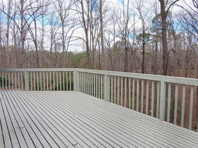 a balcony with wooden floor and trees