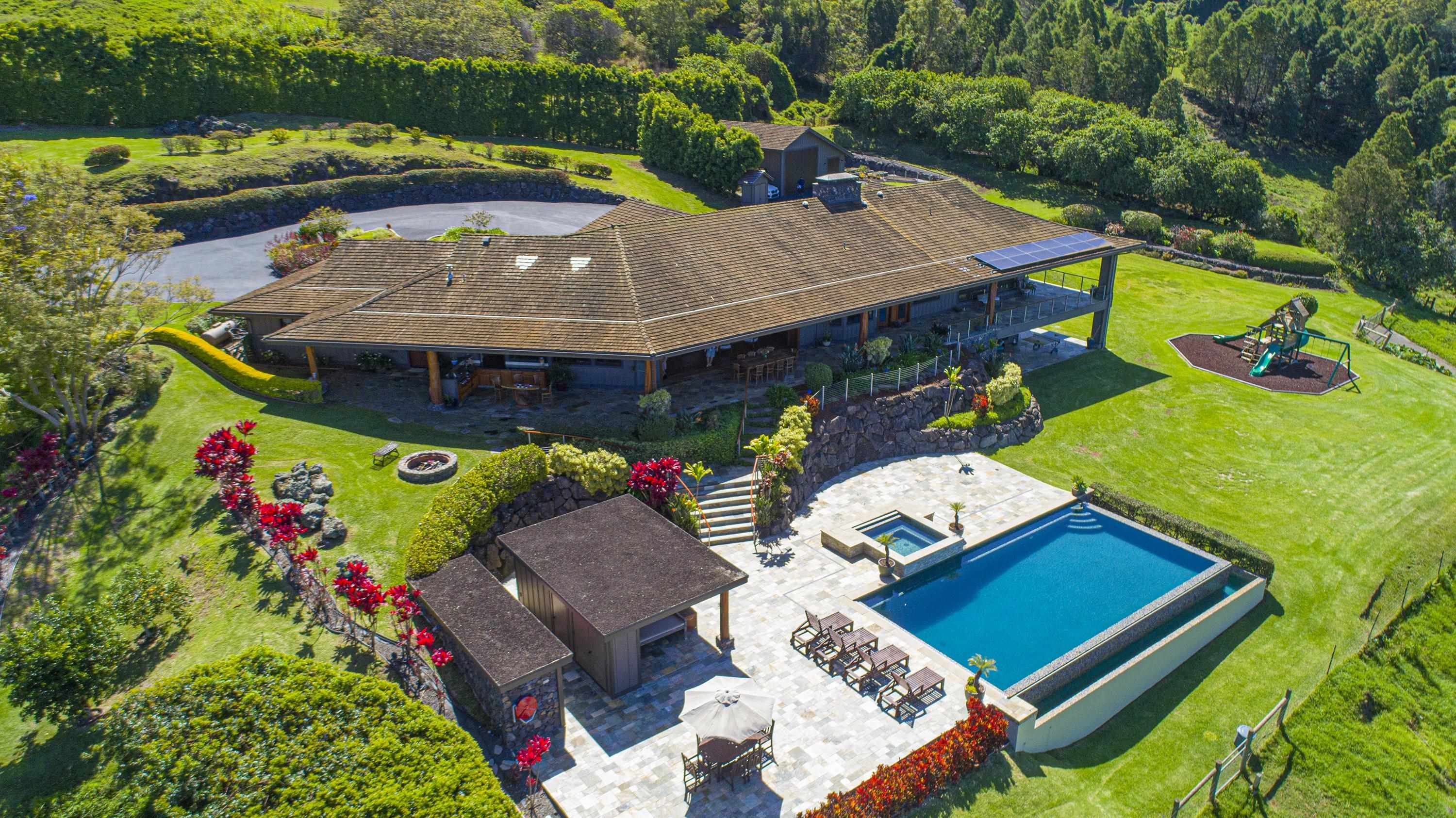 an aerial view of a house with swimming pool a patio and yard