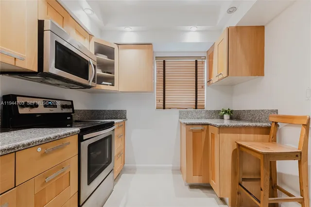 a kitchen with stainless steel appliances granite countertop a stove microwave and sink