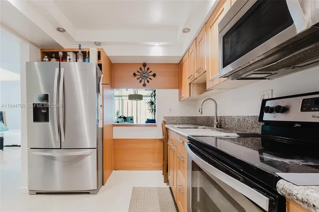 a kitchen with stainless steel appliances granite countertop a refrigerator and a sink