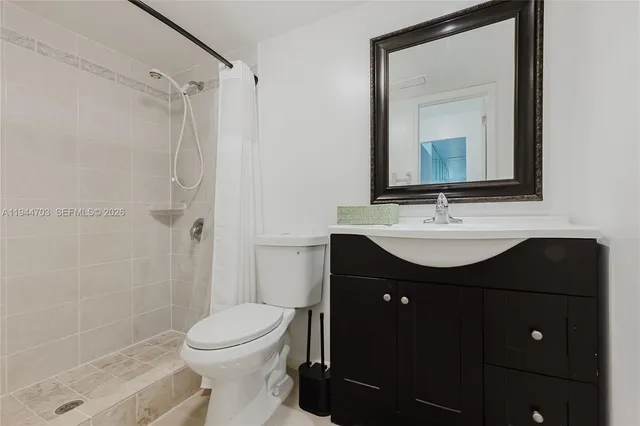 a bathroom with a sink vanity mirror and toilet