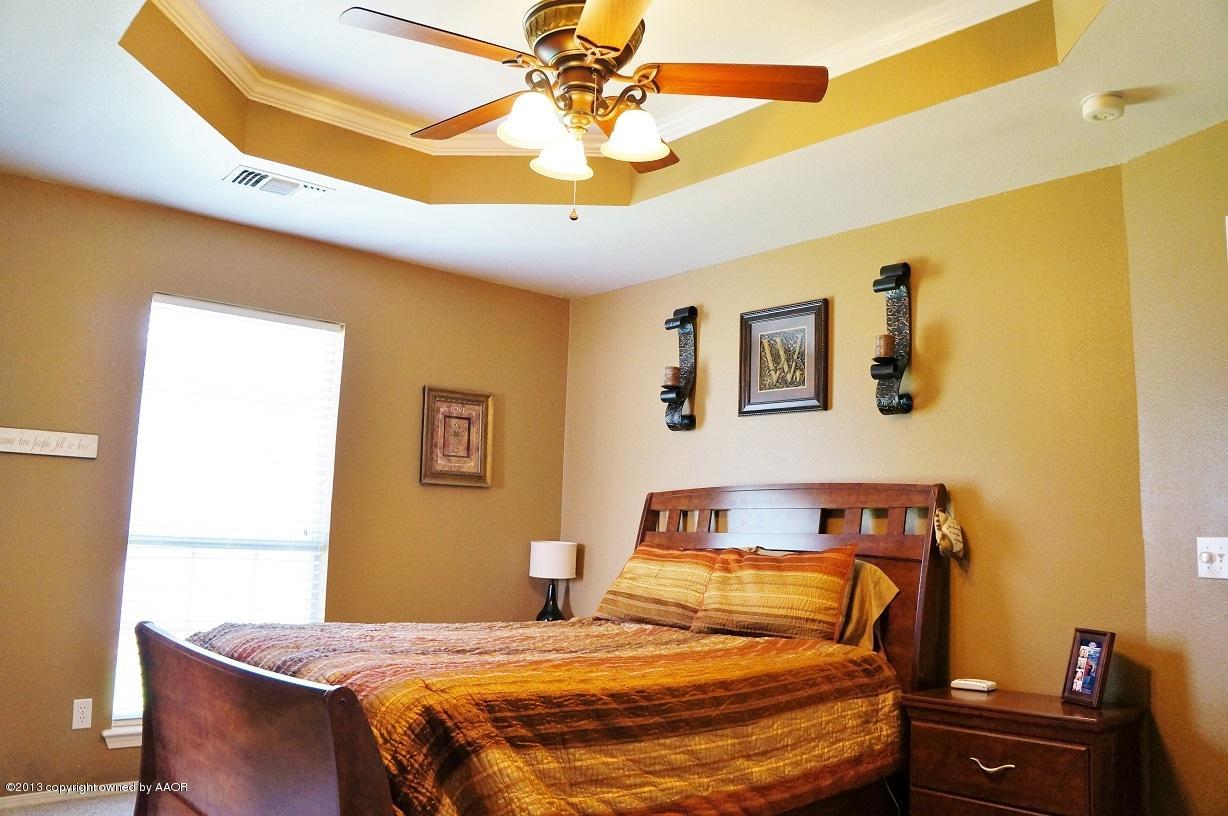 8012 Claret Street Amarillo, TX 79110 - Photo 15 of 25 a bedroom with a bed and a chandelier