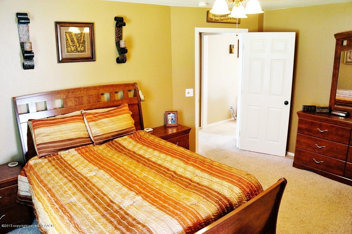 8012 Claret Street Amarillo, TX 79110 - Photo 16 of 25 a bedroom with a bed and wooden floor