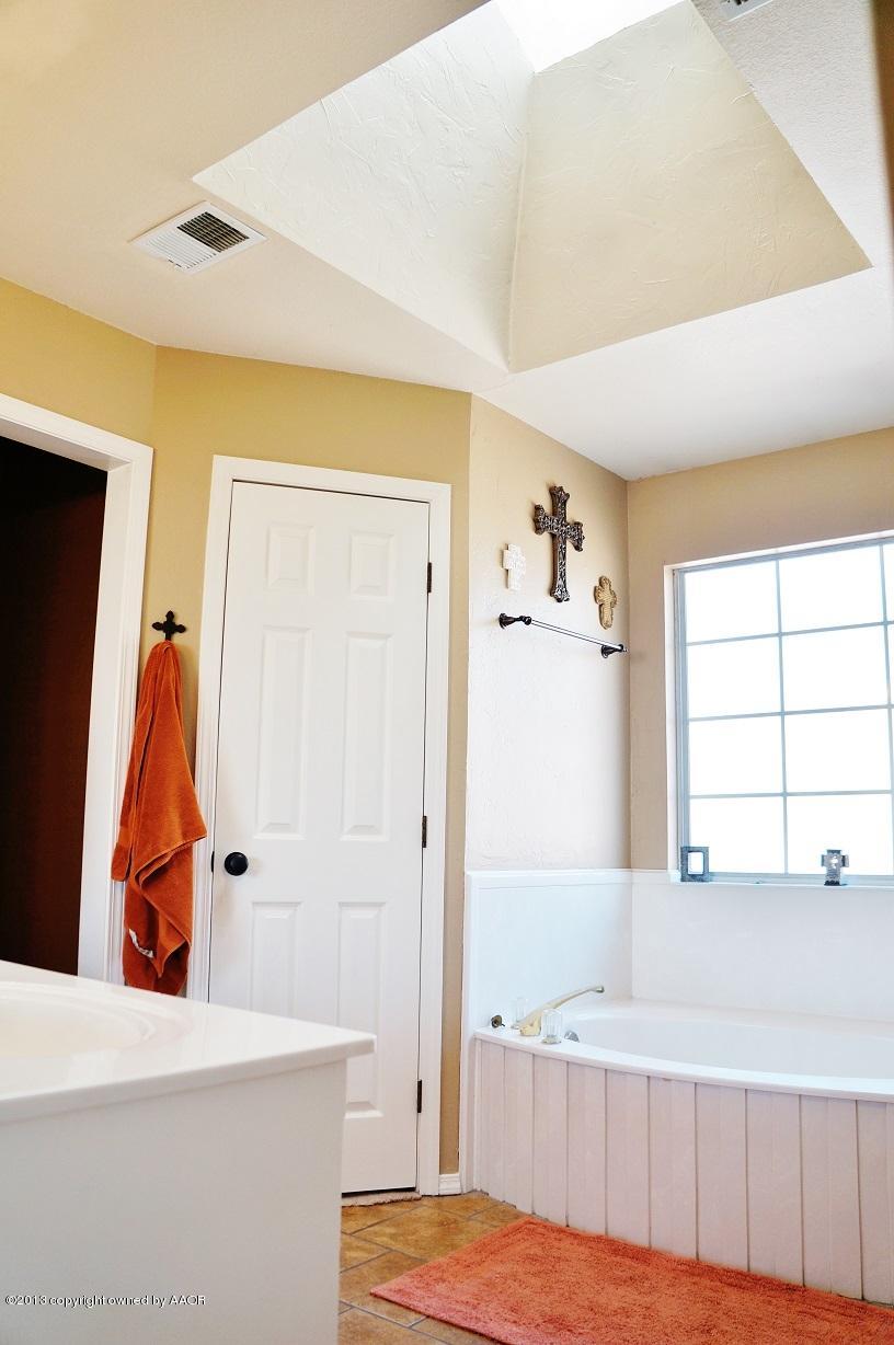 8012 Claret Street Amarillo, TX 79110 - Photo 17 of 25 a bathroom with a tub and a window