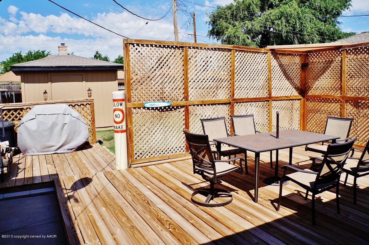 8012 Claret Street Amarillo, TX 79110 - Photo 22 of 25 a view of a roof deck with table and chairs a barbeque with wooden floor and fence