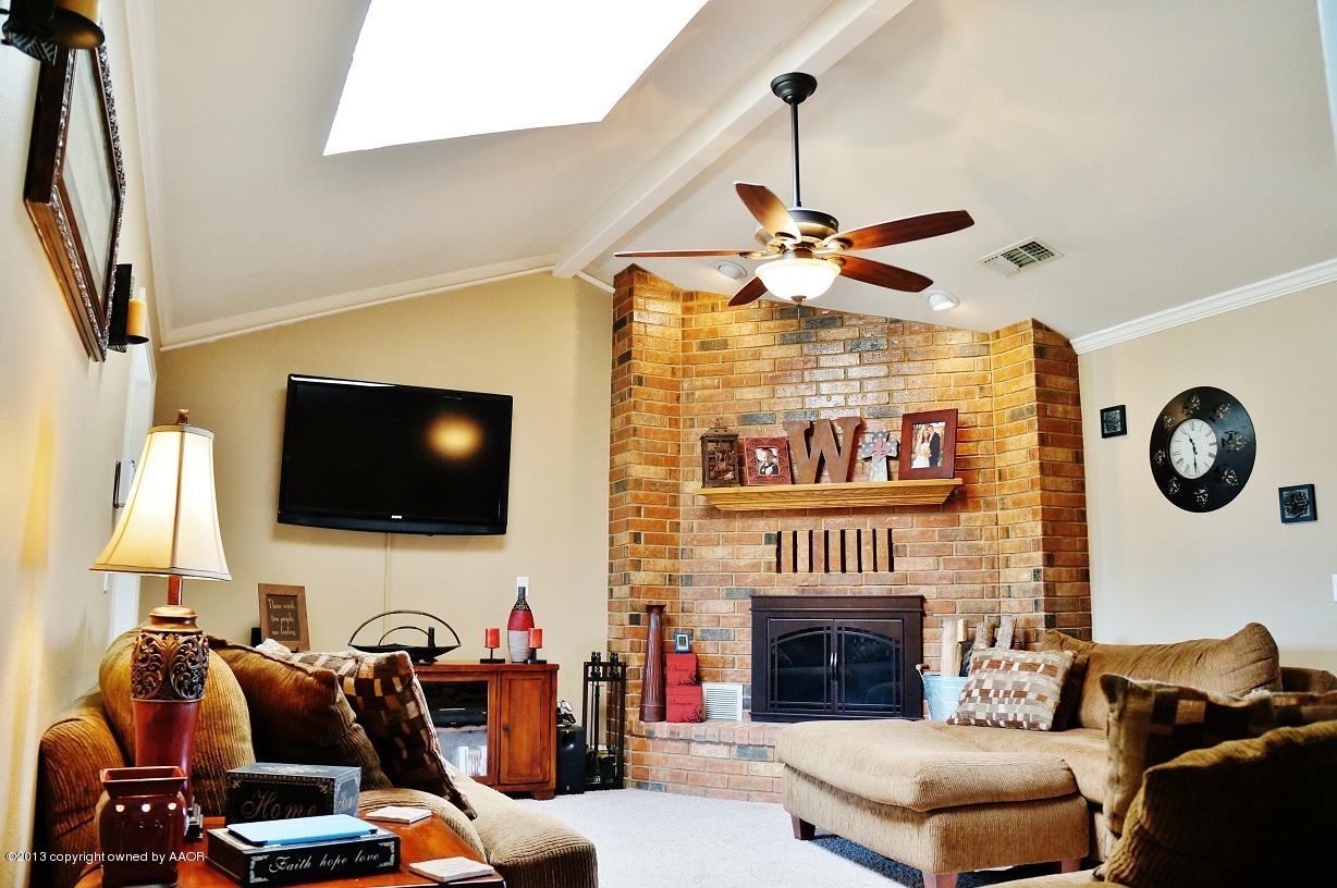8012 Claret Street Amarillo, TX 79110 - Photo 6 of 25 a living room with furniture a fireplace and a flat screen tv