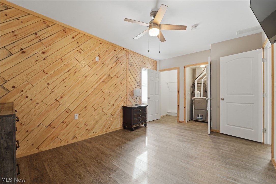 5919 Lake Road West, Unit 33 Ashtabula, OH 44004 - Photo 13 of 22 Unfurnished bedroom with wooden walls, light wood finished floors, and ceiling fan