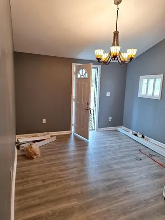 a view of a room with wooden floor and chandelier