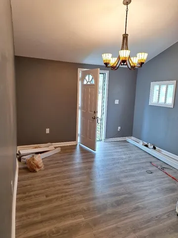 a view of a room with wooden floor and chandelier