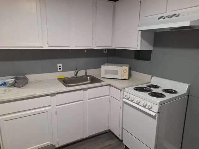 a kitchen with white cabinets and white appliances
