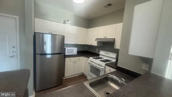 a kitchen with stainless steel appliances a refrigerator stove and sink