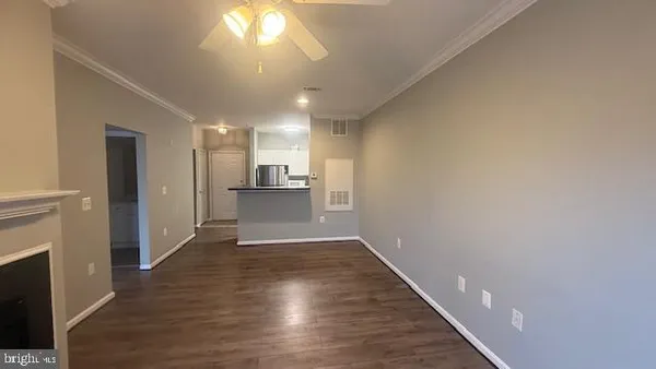 a view of a hallway with wooden floor and a kitchen