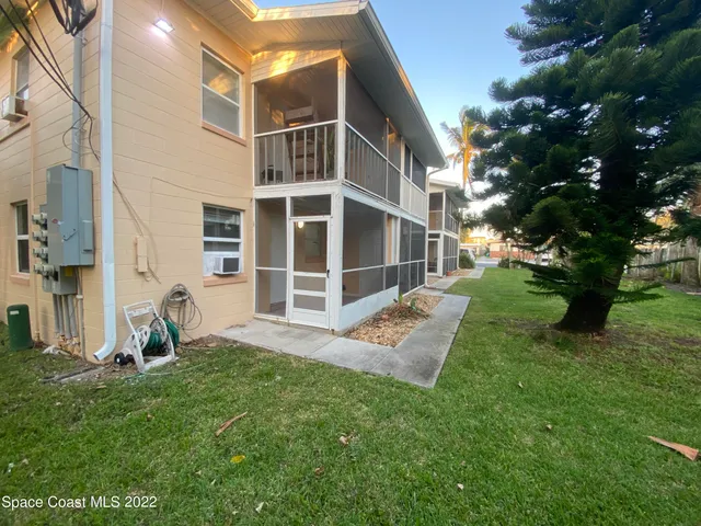a view of a backyard with wooden fence and a bench