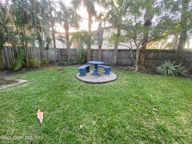 a backyard of a house with table and chairs