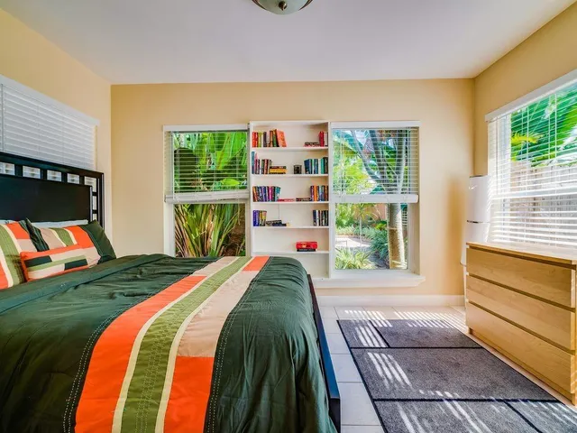 a bed sitting in a bedroom next to a window