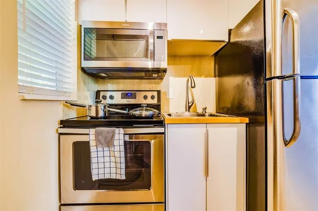 a kitchen with stainless steel appliances granite countertop a stove and a refrigerator