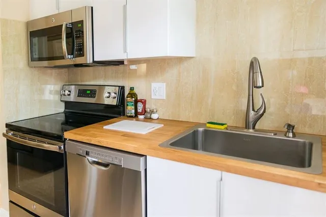 a kitchen with stainless steel appliances granite countertop a sink and a stove