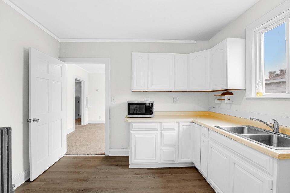 650 119th Street, Unit 1 Whiting, IN 46394 - Photo 12 of 17 a view of a kitchen with white cabinets and wooden floor