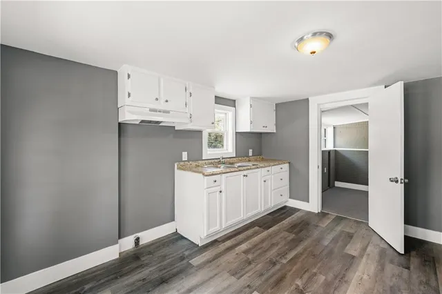 a kitchen with granite countertop white cabinets and stainless steel appliances