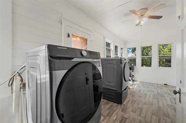 a bedroom with a bed table and flat screen tv