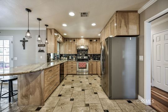 725 West Howell Avenue Ridgecrest, CA 93555 - Photo 13 of 35 a kitchen with stainless steel appliances granite countertop a refrigerator and a sink