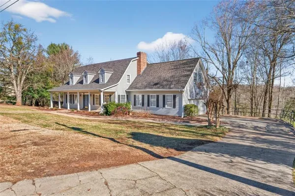 a view of a house with a large space and a car parked on the road