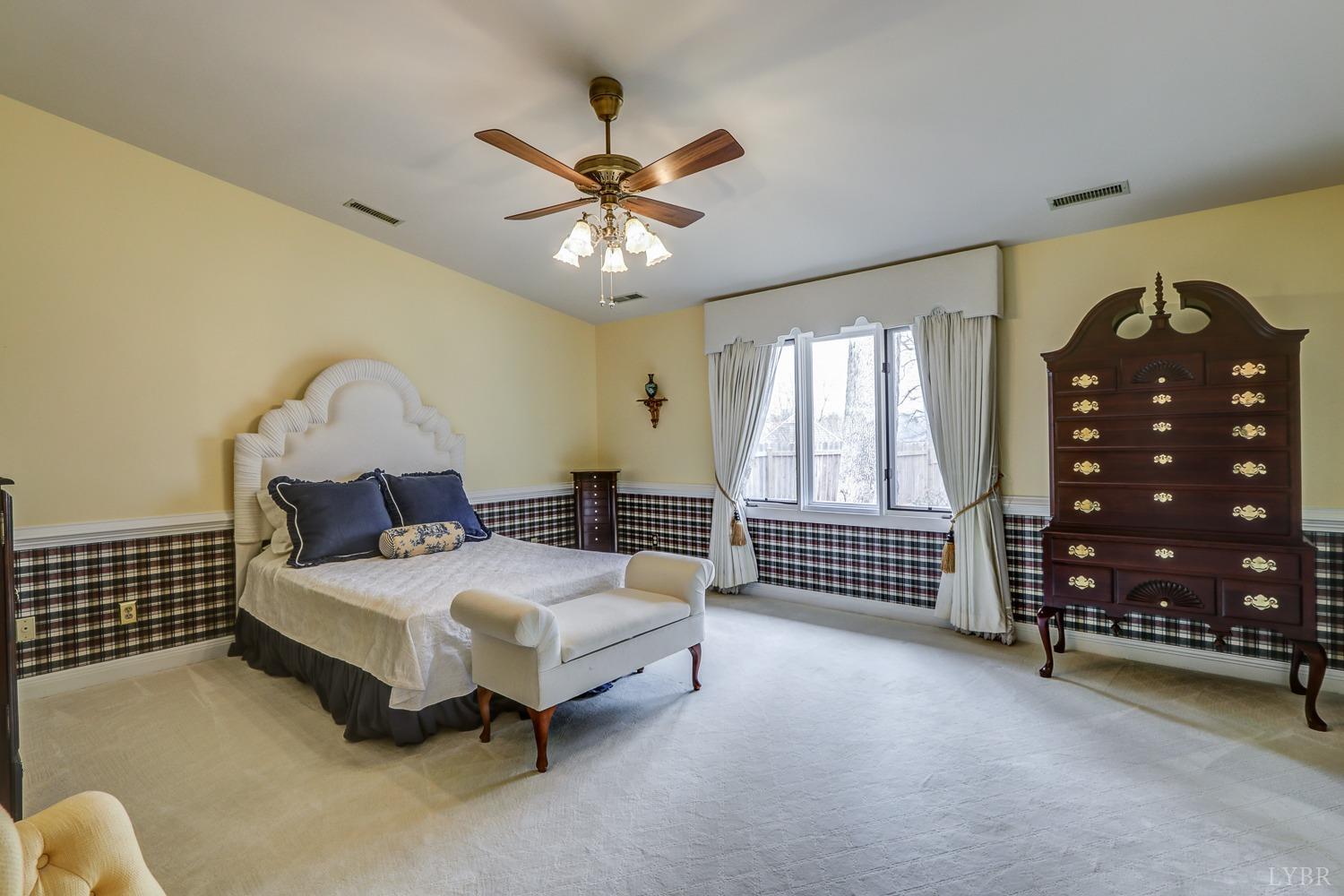 117 Sailview Drive Forest, VA 24551 - Photo 38 of 55 a spacious bedroom with a bed a chandelier and a dresser