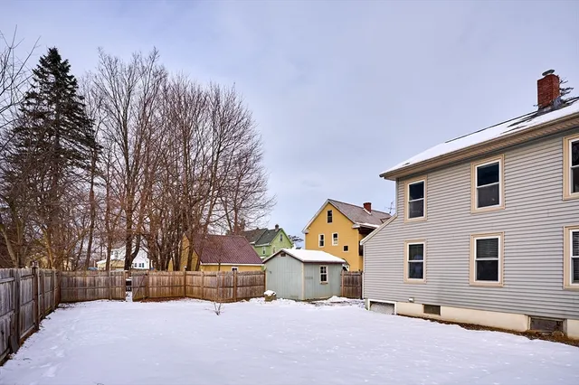 a view of a white house with a yard covered in snow