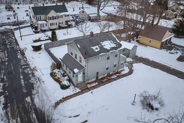 an aerial view of a house with a mountain