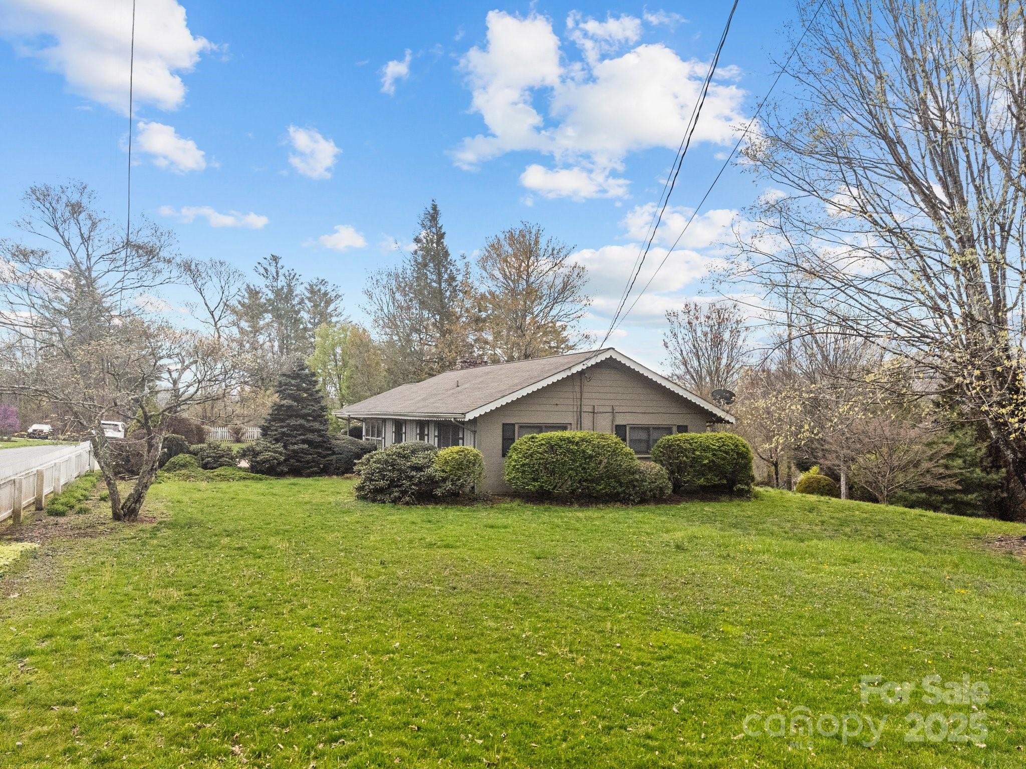 457 Overlook Drive Spruce Pine, NC 28777 - Photo 28 of 33 a yellow house sitting in middle of the green field
