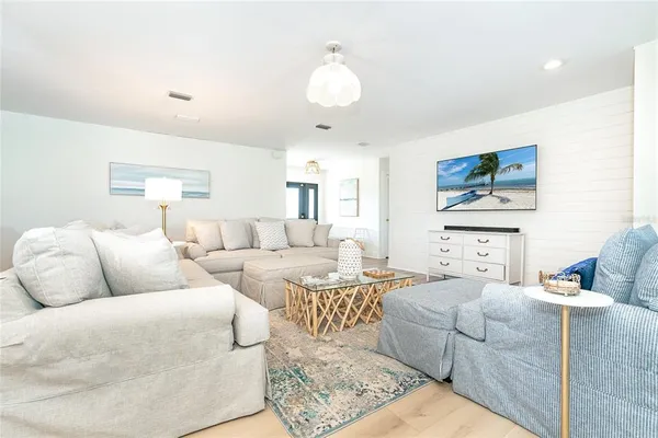 a living room with furniture and a chandelier