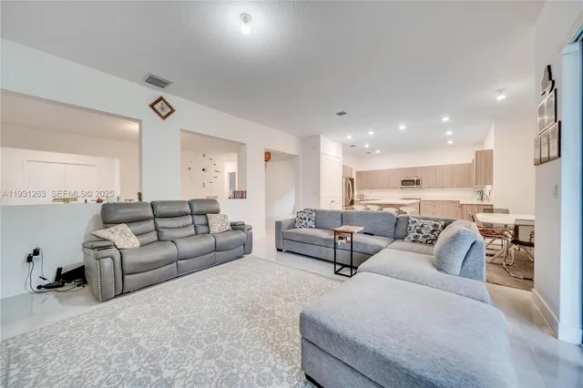 a kitchen with a sink chairs and white cabinets
