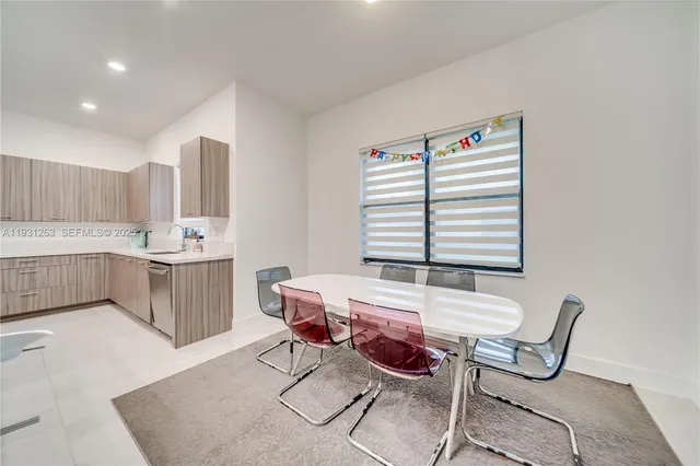 a large kitchen with a large counter top a sink a window and a couch