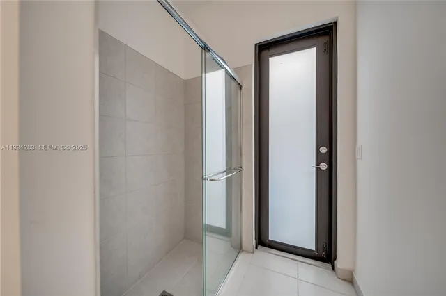 a bedroom with bed a flat tv screen and a night stand