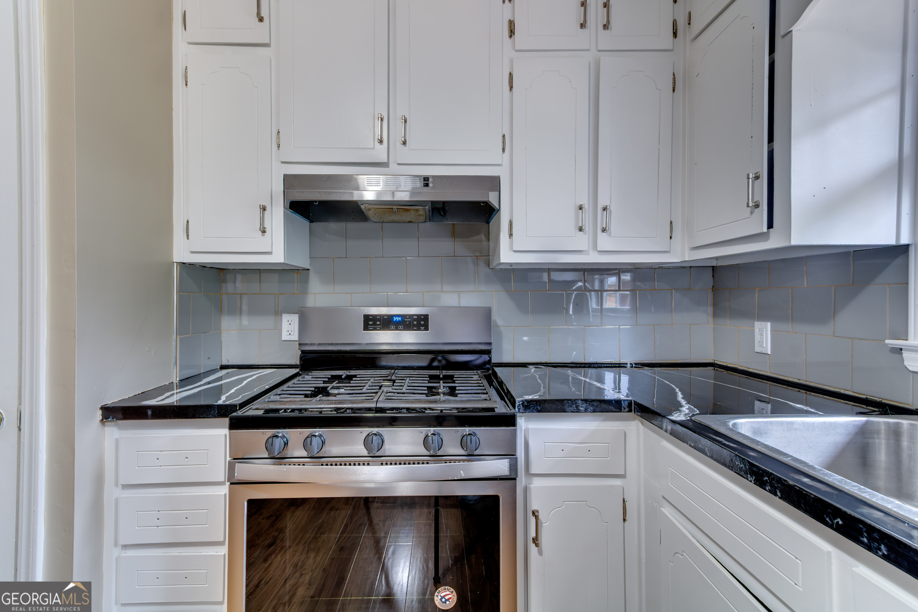 3959 Emerald Springs Court, Unit 3 Decatur, GA 30035 - Photo 9 of 27 a kitchen with granite countertop white cabinets and stainless steel appliances